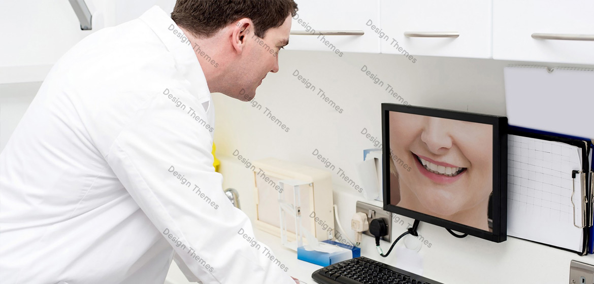 a dentist looking at the screen of a computer