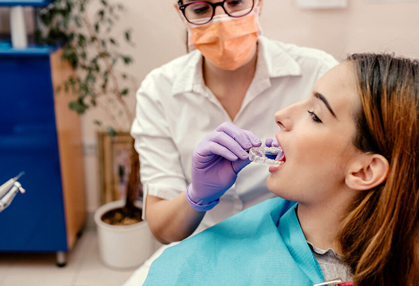 a woman dentist performing Invisalign