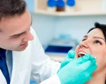 a dentist checking the teeth of a woman