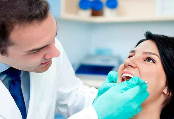 a dentist checking the teeth of a woman