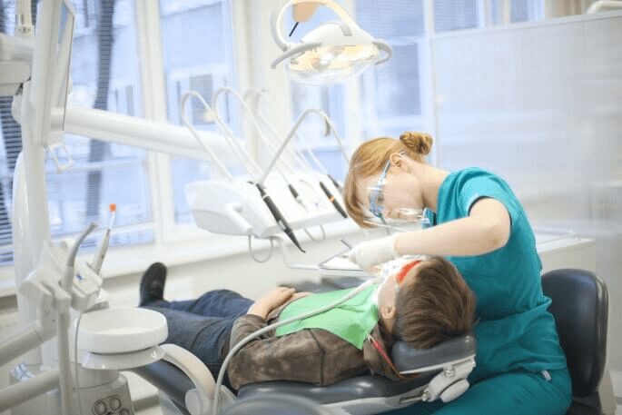 Pediatric dentist treating boy in dental chair Pediatric dentist treating boy in dental chair